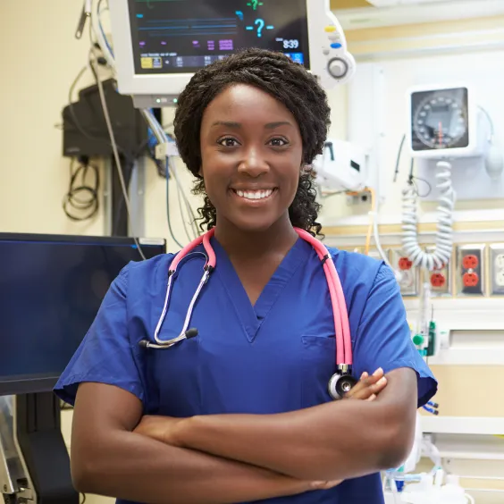 Person wearing blue medical scrubs with a stethoscope, standing in a clinical setting