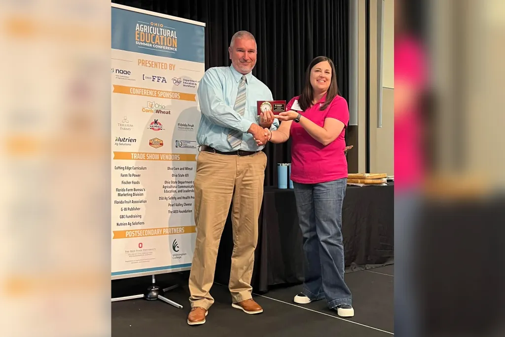 Alison Derringer, Agricultural Education instructor at Twin Valley South High School and past President of the Ohio Association of Agricultural Educators presents Edison State Director of Agriculture Program Brad Lentz with the OAAE award for Outstanding Postsecondary Agricultural Program at the OAAE summer conference.