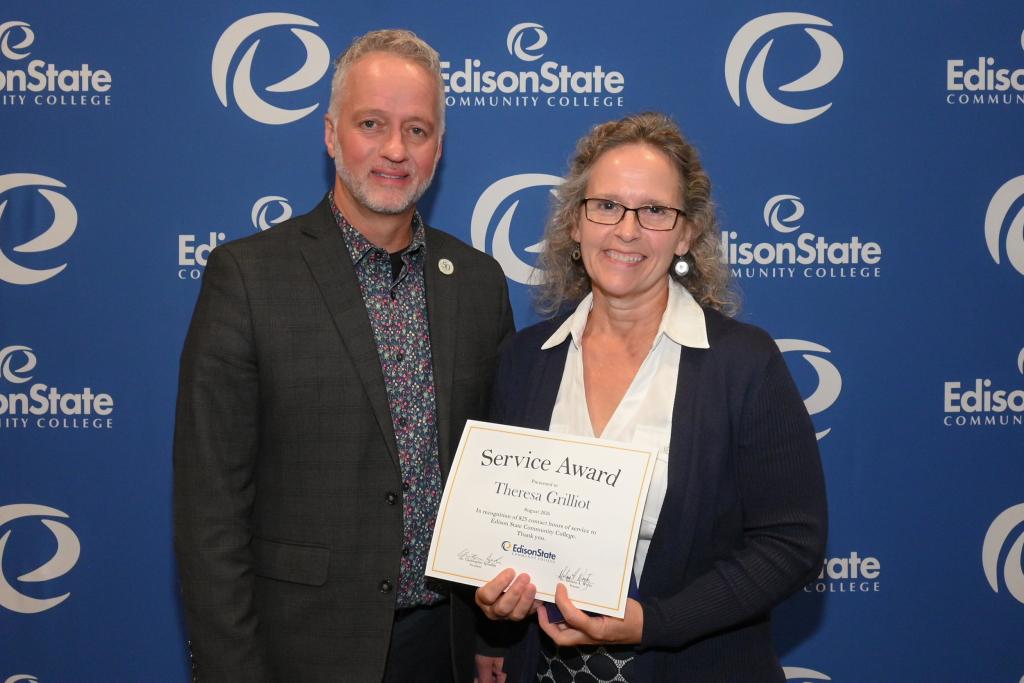 President Dr. Chris Spradlin presents Theresa Grilliot with a gift for reaching 825 service hours in her career at Edison State.