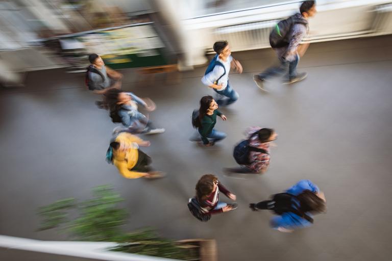 Overhead view of students walking a hall.