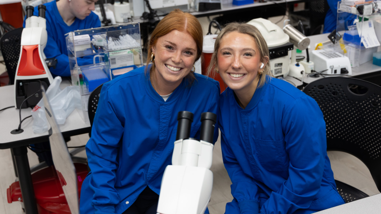 MLT Students in a classroom, smiling at the camera