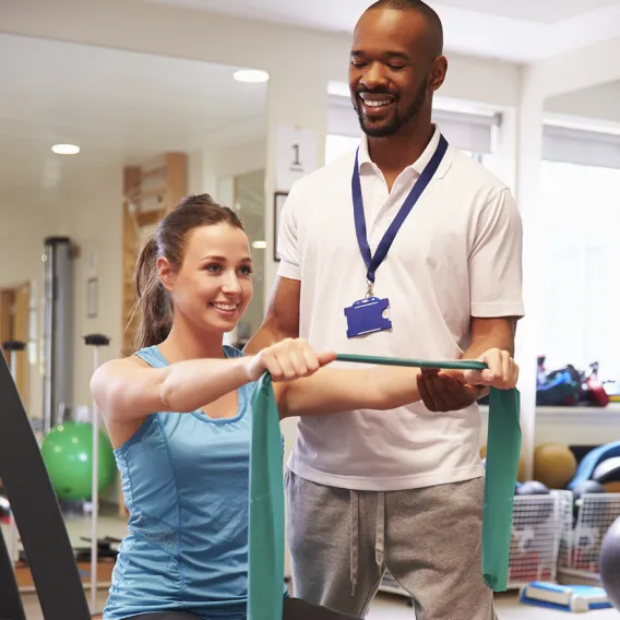  Physical Therapist Assistant Supporting Patient During Exercise 