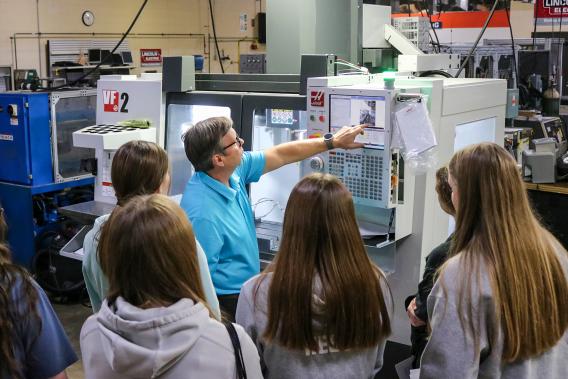 Mike Rowe, a CNC programming adjunct instructor at Edison State, shows young women how to program a CNC machine during last fall’s Women in STEMM Expo event.