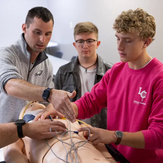 EMT Students Practicing Patient Assessment On Manikin