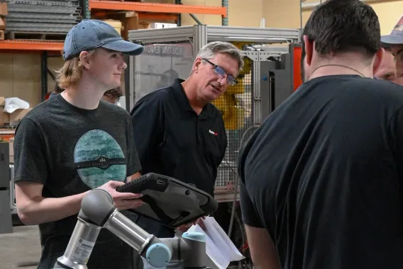 Student and instructor work with a collaborative robotic arm during a manufacturing technology lab session.