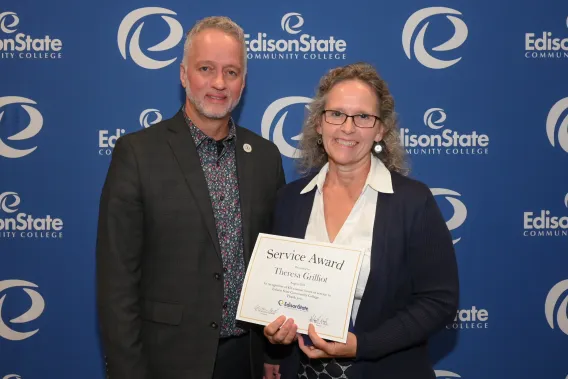 President Dr. Chris Spradlin presents Theresa Grilliot with a gift for reaching 825 service hours in her career at Edison State.